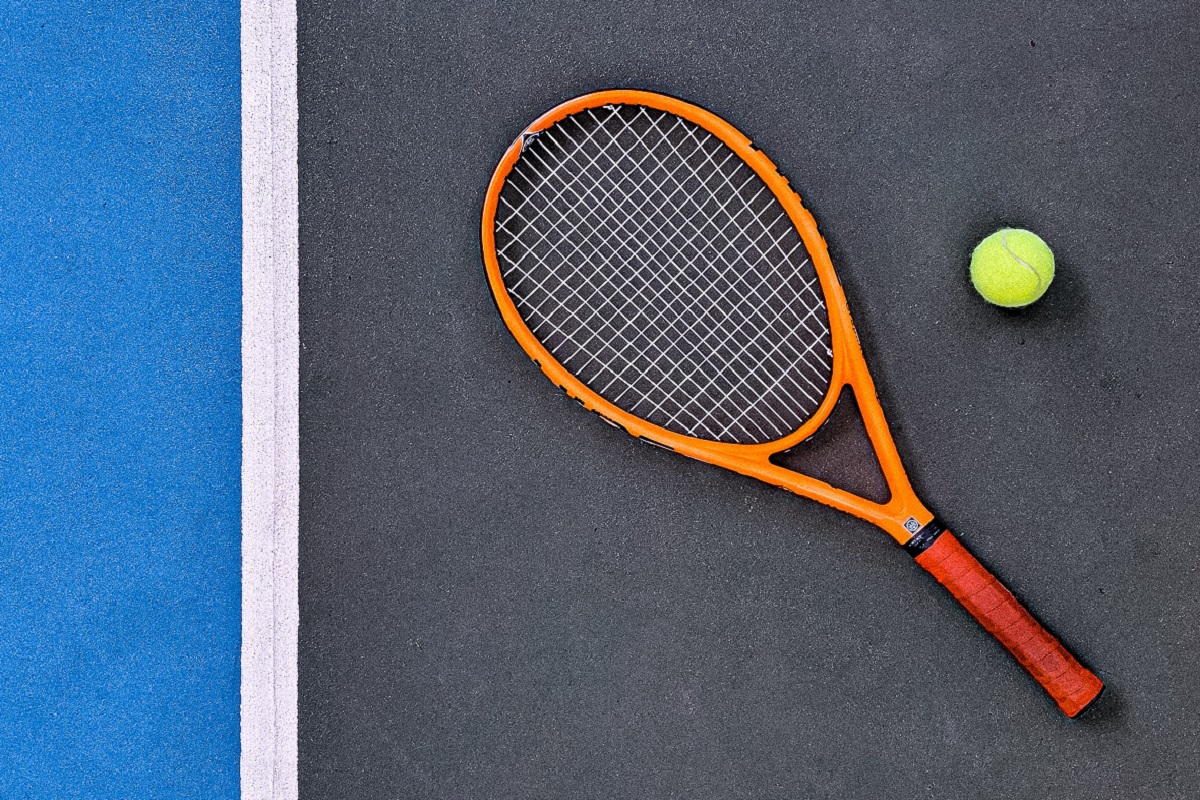 Photo of a tennis racquet and a tennis ball.