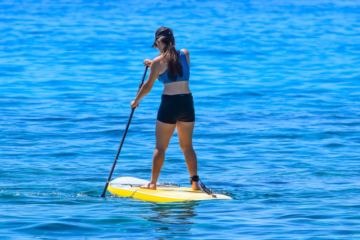 A woman paddleboarding on a lake.